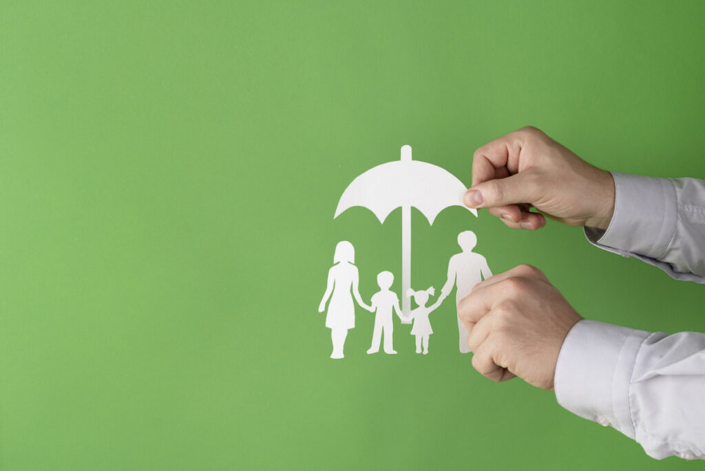 Paraguas cortado en papel simboliza la protección familiar con un seguro de vida