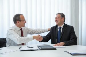 Men happily shake hands following a business insurance agreement