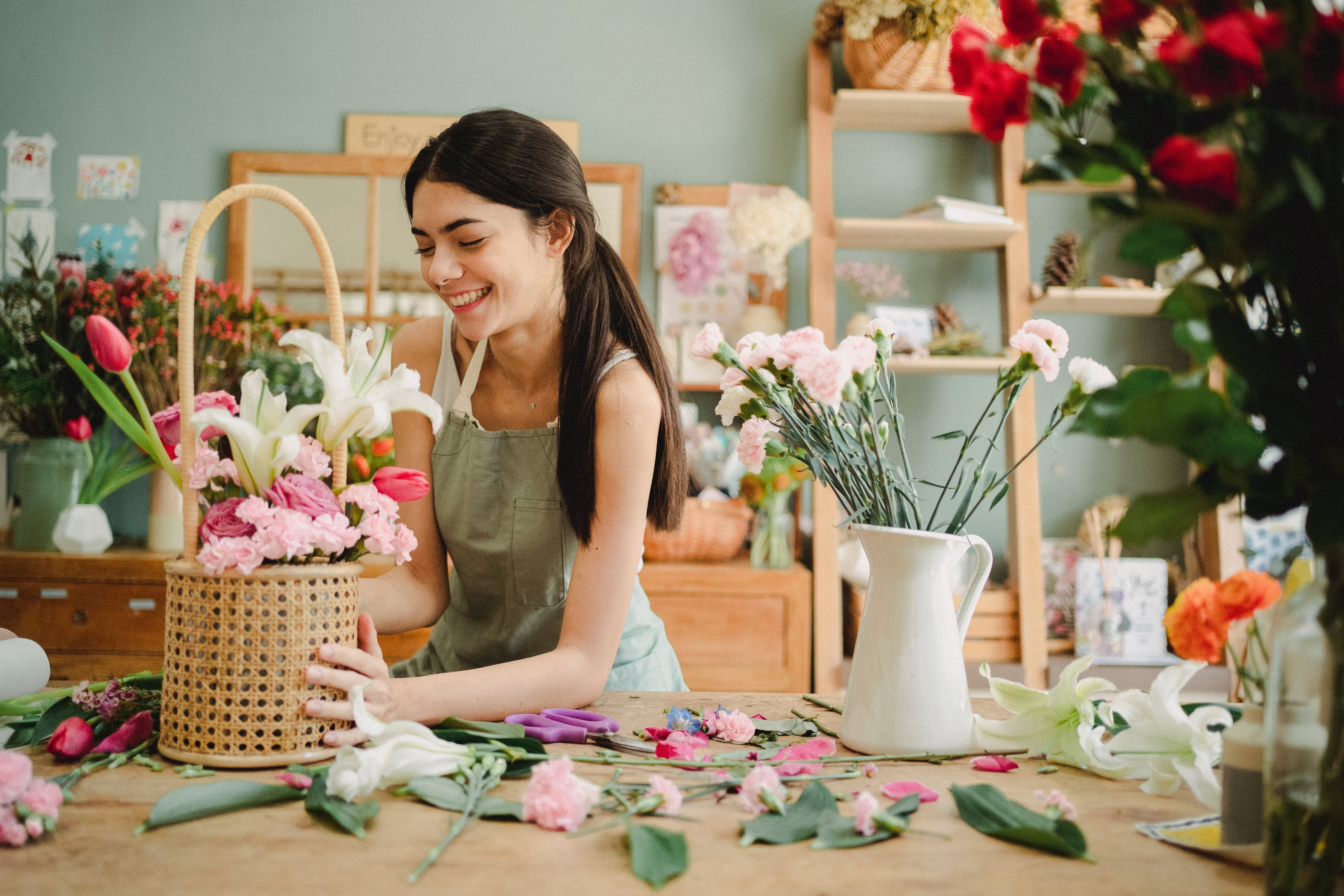 Mujer arreglando flores para su negocio con seguro