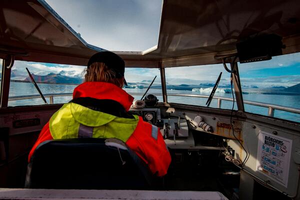 A rear view of helmsman driving a boat