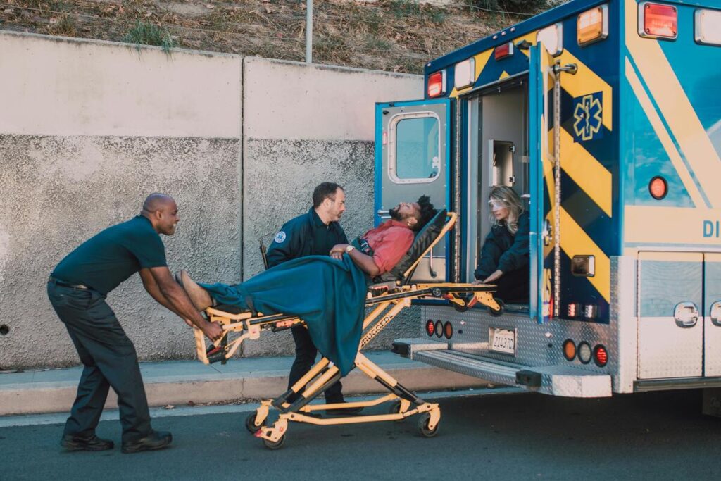 An injured person on a stretcher is being transferred to an ambulance