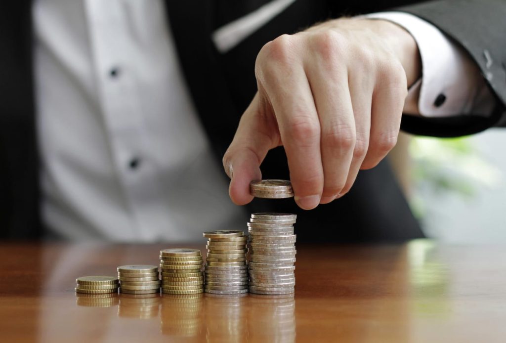 Un hombre apilando monedas 