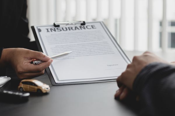 Agente de seguros le pide al cliente que firme un contrato.