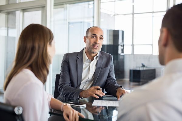 Propietarios de empresas conversan con un agente de seguros.