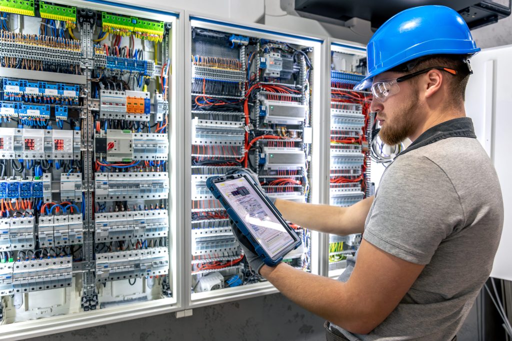 Male electrician working on the switchboard