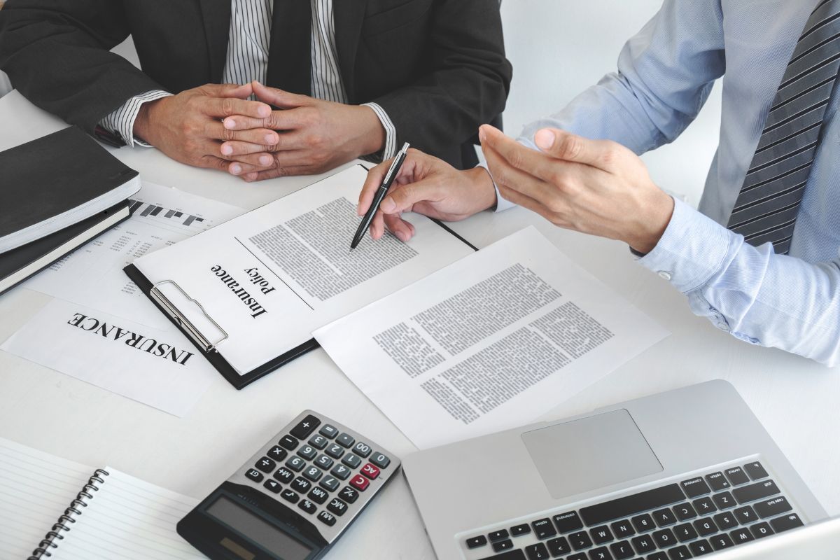 Cliente revisando su plan de seguro personal con un corredor.