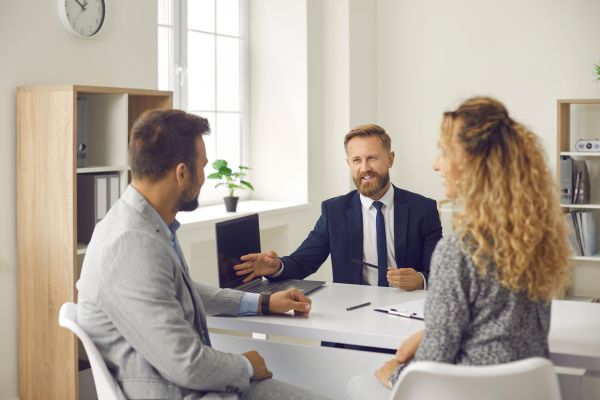 Corredor ayuda a los clientes a comprender la póliza de seguro personal.